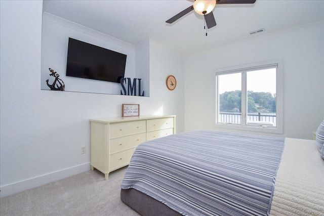 bedroom featuring crown molding, visible vents, a ceiling fan, light carpet, and baseboards