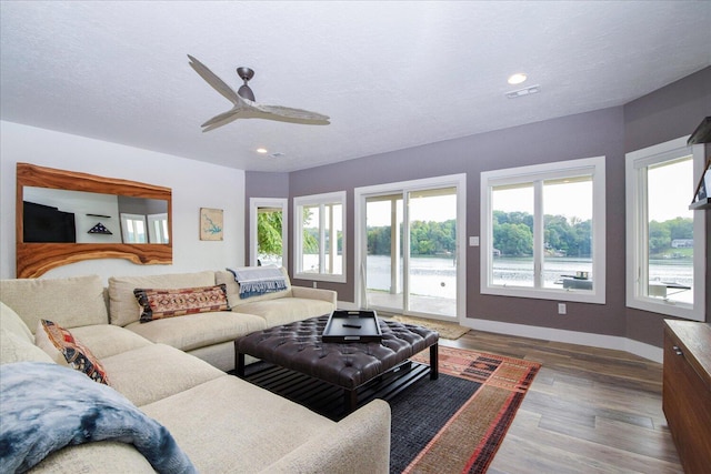 living room with recessed lighting, dark wood-style flooring, plenty of natural light, and baseboards