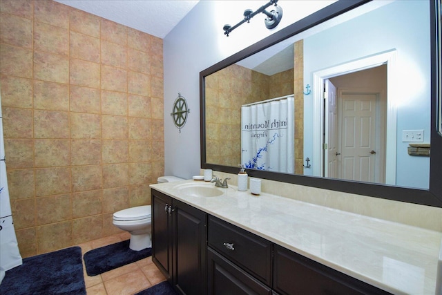 bathroom with toilet, a shower with shower curtain, tile walls, vanity, and tile patterned floors