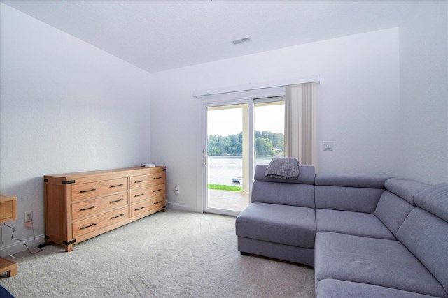 living room featuring baseboards, visible vents, and light colored carpet