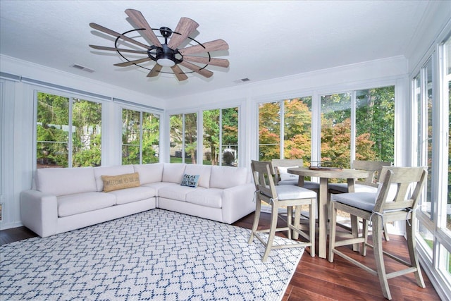 sunroom / solarium featuring visible vents, a wealth of natural light, and a ceiling fan