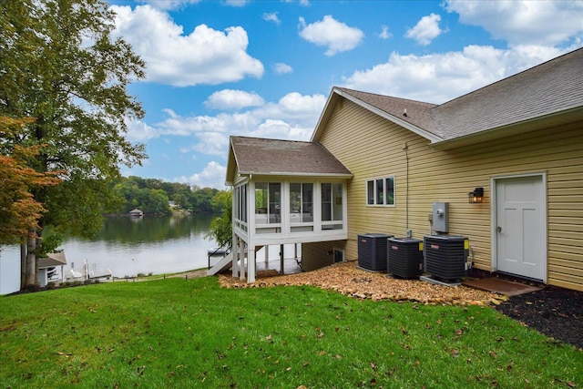 back of house with a yard, a water view, a sunroom, and central air condition unit