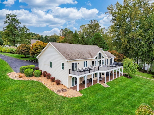 back of property featuring a deck, a yard, a patio, and driveway