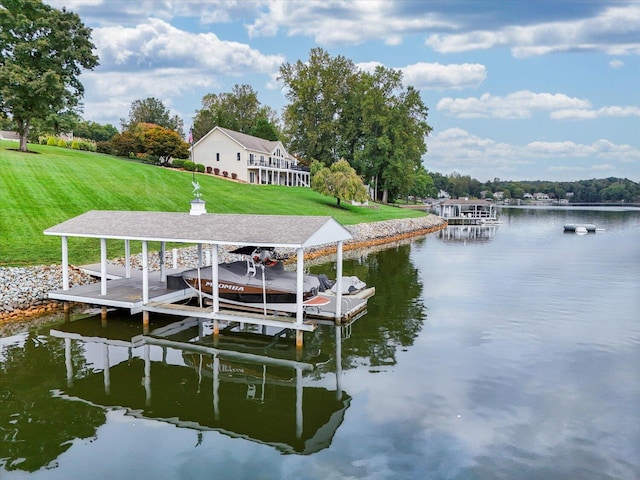 view of dock with a water view, a yard, and boat lift