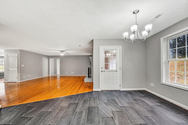 unfurnished room with dark wood finished floors, visible vents, and baseboards