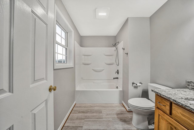 bathroom with baseboards, vanity, toilet, and bathing tub / shower combination