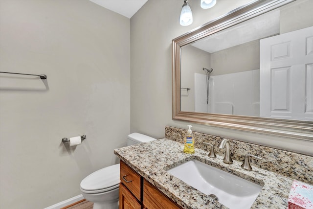 full bathroom featuring a shower, vanity, toilet, and baseboards