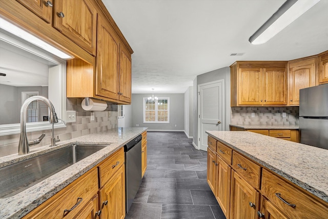 kitchen featuring stainless steel appliances, a sink, visible vents, and brown cabinets