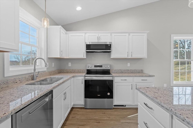 kitchen featuring a sink, lofted ceiling, white cabinets, and stainless steel appliances