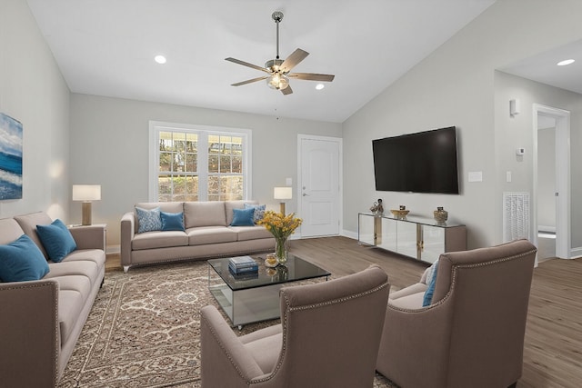 living area with visible vents, lofted ceiling, a ceiling fan, and wood finished floors