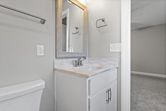 bathroom featuring vanity, toilet, and baseboards