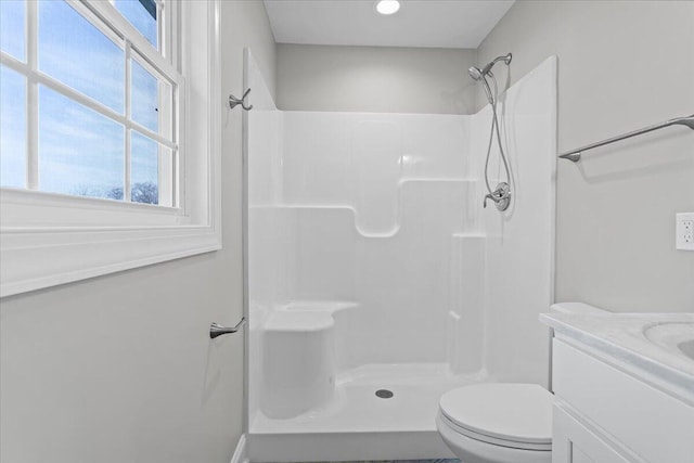 full bathroom with toilet, vanity, and walk in shower