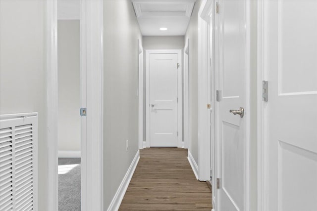 hall featuring wood finished floors, attic access, baseboards, and visible vents