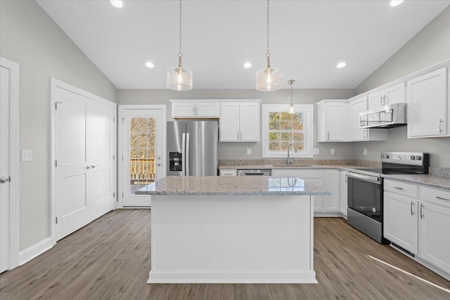 kitchen with a kitchen island, a sink, vaulted ceiling, appliances with stainless steel finishes, and white cabinetry