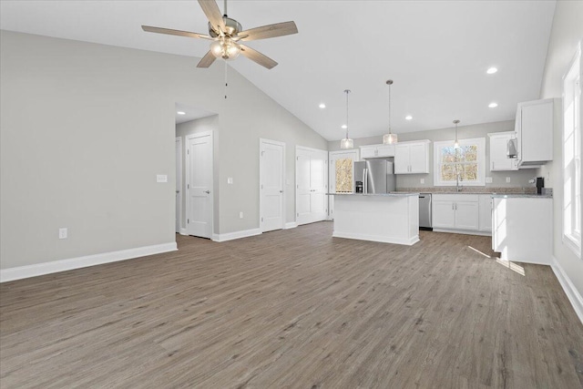 kitchen with a ceiling fan, light wood-style flooring, white cabinets, appliances with stainless steel finishes, and open floor plan