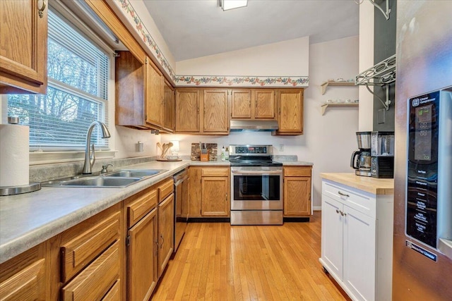 kitchen with under cabinet range hood, stainless steel appliances, a sink, and light countertops