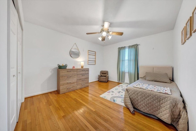 bedroom featuring light wood finished floors, a ceiling fan, and baseboards