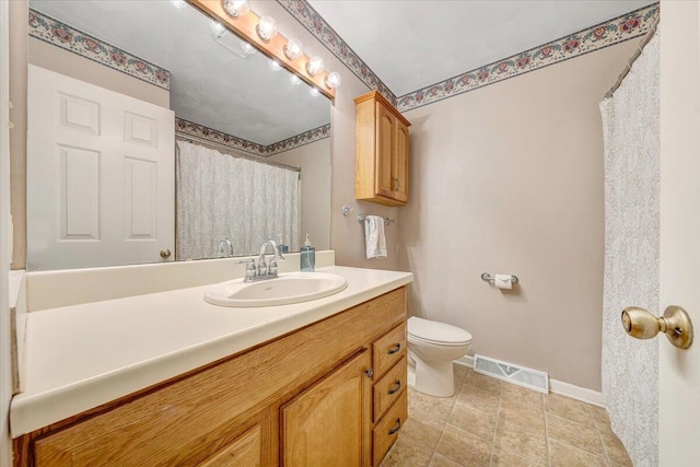 bathroom featuring visible vents, toilet, vanity, and baseboards