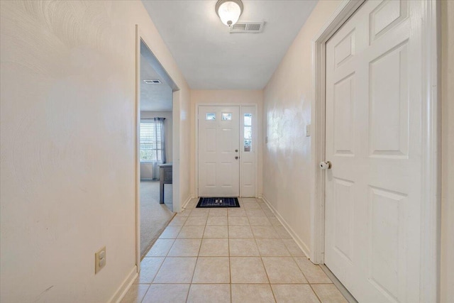 doorway to outside featuring light tile patterned floors, visible vents, and baseboards