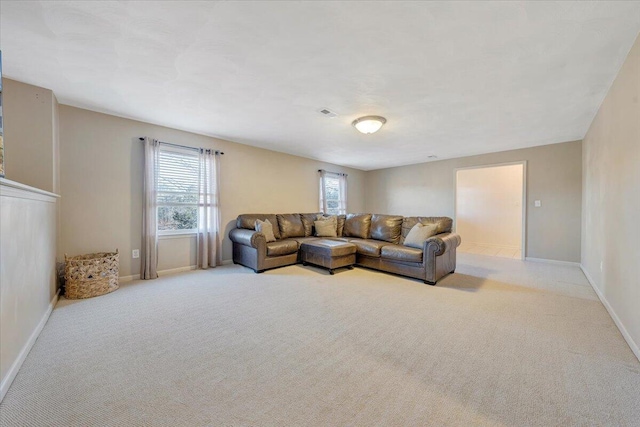 living area with light colored carpet and baseboards