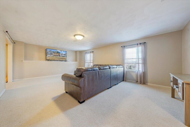 living room with light carpet, a healthy amount of sunlight, and baseboards