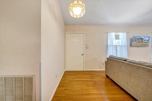 foyer entrance with light wood-type flooring, baseboards, and visible vents