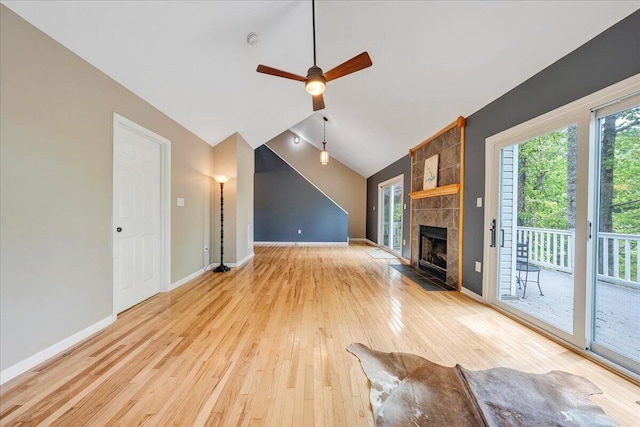 unfurnished living room with lofted ceiling, a ceiling fan, baseboards, light wood-style floors, and a fireplace