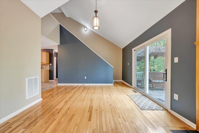 unfurnished living room featuring light wood-type flooring, visible vents, baseboards, and high vaulted ceiling