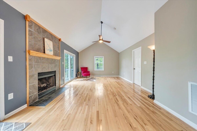 unfurnished living room with a ceiling fan, baseboards, wood-type flooring, vaulted ceiling, and a fireplace