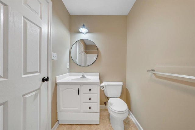 bathroom with vanity, toilet, and baseboards