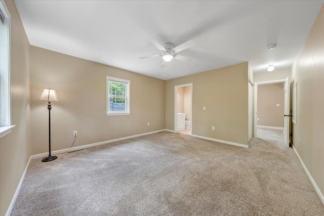 spare room with ceiling fan, carpet flooring, and baseboards