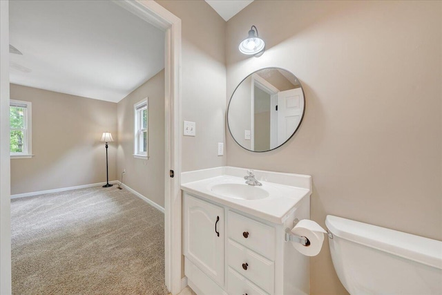 bathroom with vanity, toilet, baseboards, and plenty of natural light