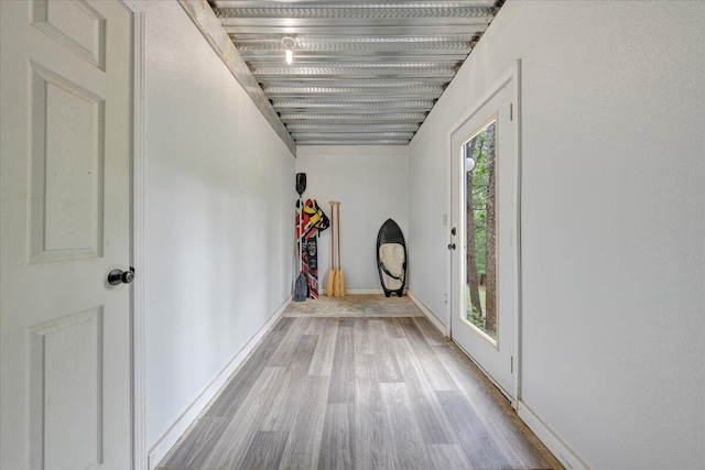 corridor featuring wood finished floors and baseboards