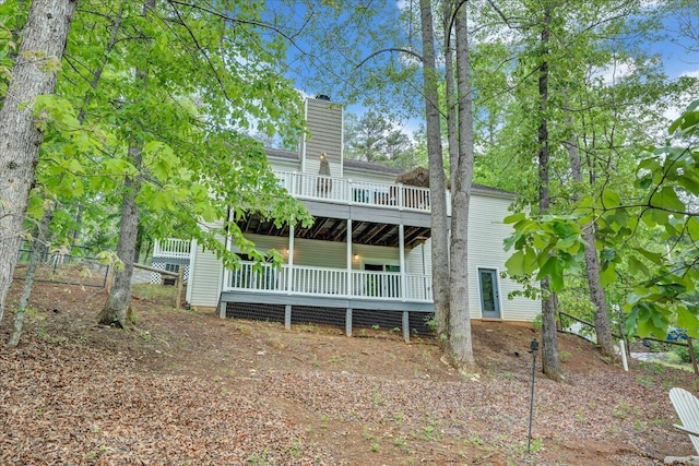 back of property featuring a chimney and a deck