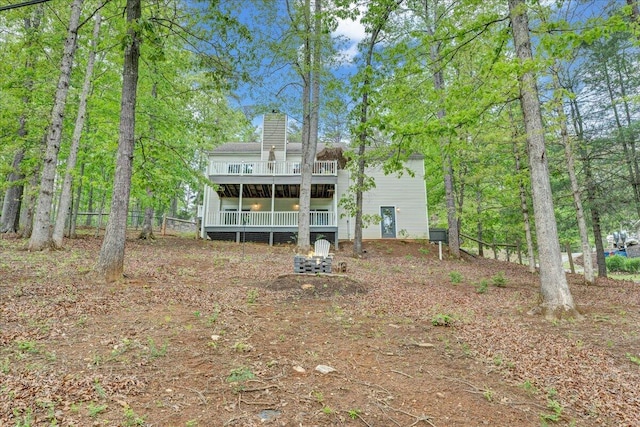 back of property with a chimney and a deck