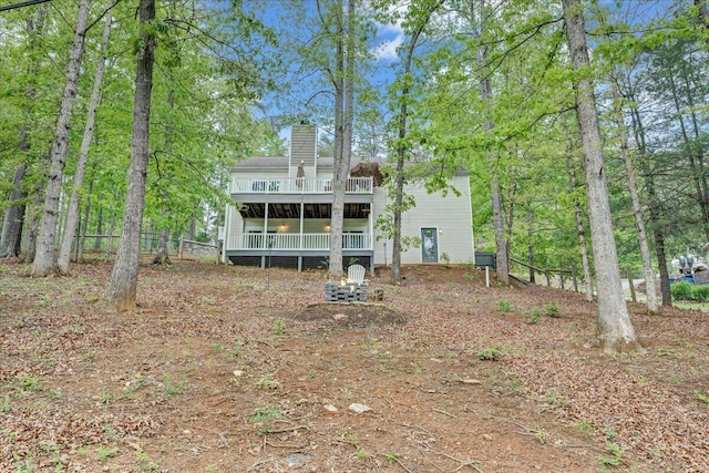 back of house featuring a chimney and a deck