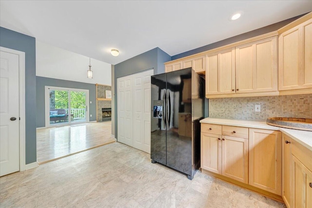 kitchen with black fridge, tasteful backsplash, light brown cabinetry, and light countertops