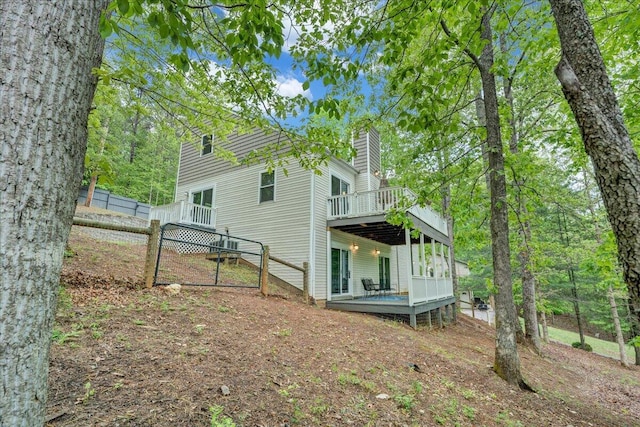 back of house with a deck and a chimney