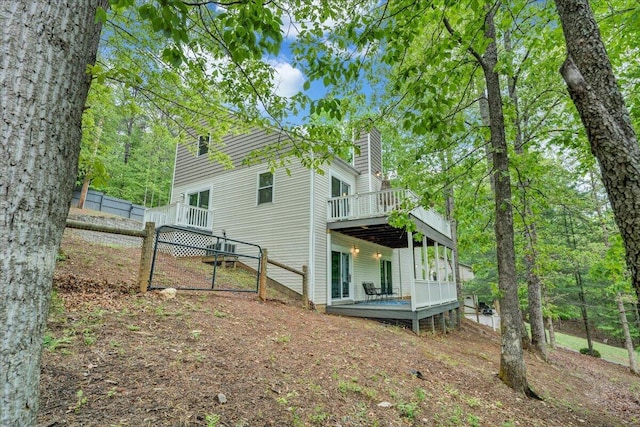 exterior space with a chimney, a deck, and fence