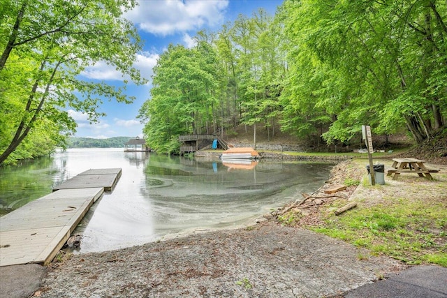 surrounding community featuring a water view and a boat dock