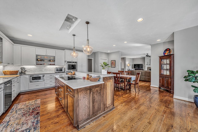 kitchen with white cabinetry, appliances with stainless steel finishes, dark wood-type flooring, and backsplash