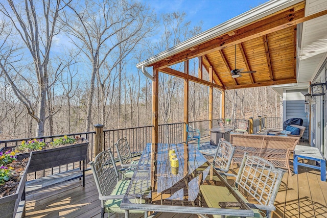 wooden terrace with ceiling fan and outdoor dining area