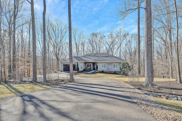 view of front of house with a garage, a front lawn, and aphalt driveway