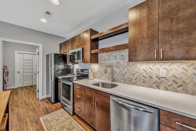 kitchen with visible vents, appliances with stainless steel finishes, light countertops, open shelves, and a sink