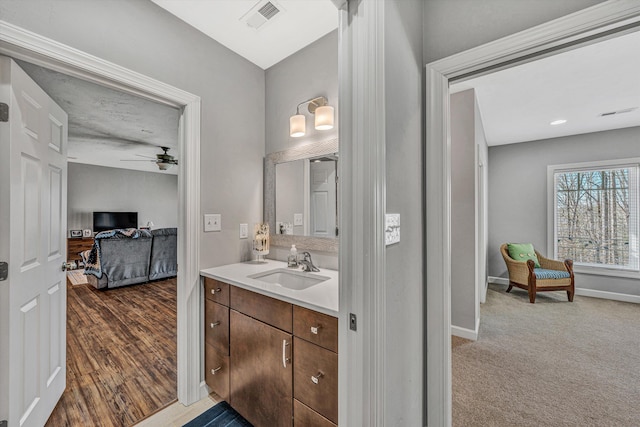 bathroom featuring baseboards, visible vents, a ceiling fan, wood finished floors, and vanity