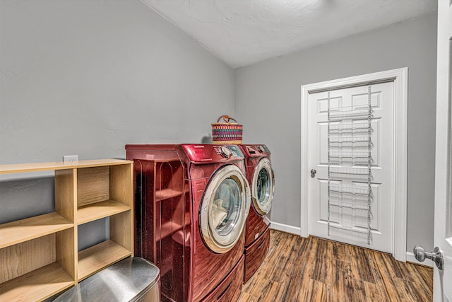 laundry room with laundry area, washer and clothes dryer, baseboards, and wood finished floors