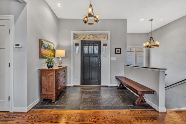 foyer with a chandelier, recessed lighting, baseboards, and stone tile floors