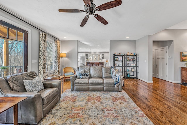 living area with baseboards, a ceiling fan, wood finished floors, and recessed lighting