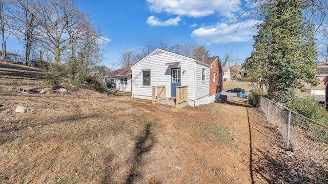 rear view of house featuring a yard and fence