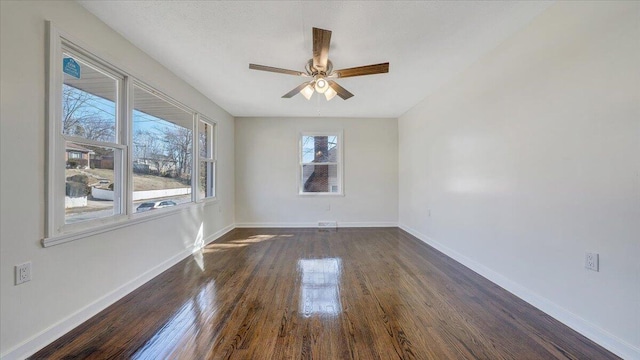 spare room featuring dark wood-type flooring, baseboards, and a ceiling fan